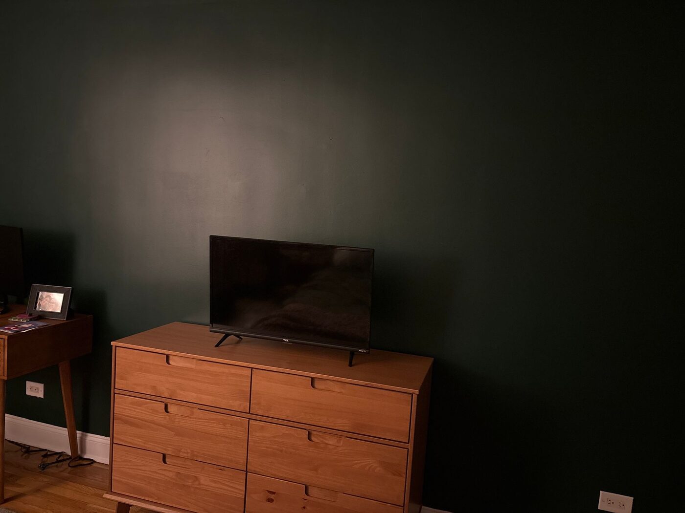Bedroom finished in deep green with hardwood floor
