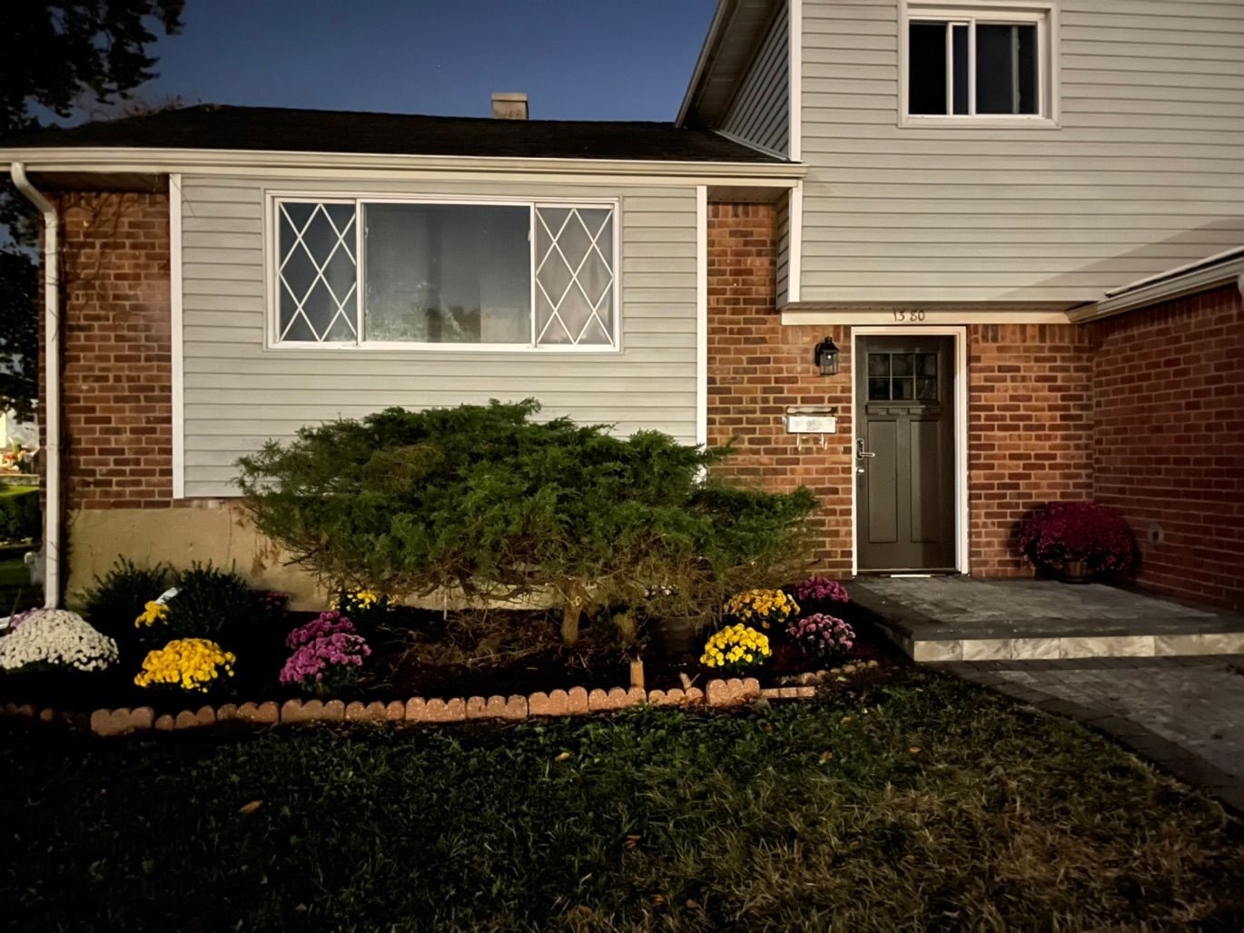 Brick home exterior with finished front steps and planted beds