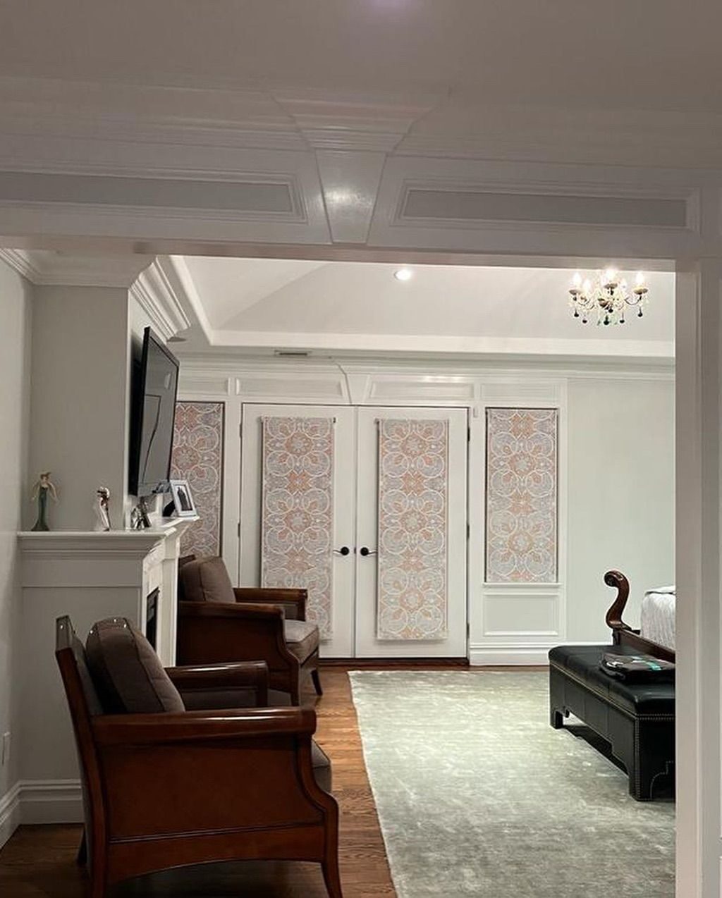 Finished living room with fireplace, coffered ceiling, and French doors
